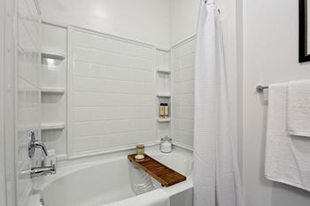 A white bathroom with a tub and a shower